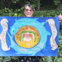 Adrienne Varady holding up her hand-painted sukkah poster, "Sukkah of the Leviathan" (Adrienne Varady 2023, photo credit: Aharon Varady)